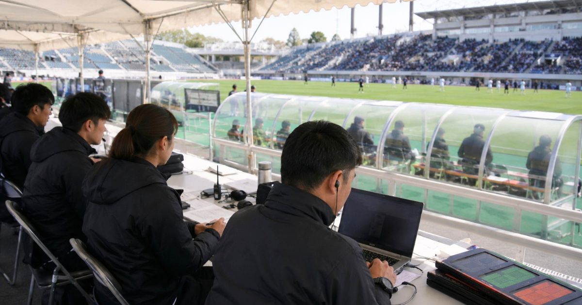インカレの試合会場で、運営スタッフが本部席から試合進行や記録を管理する様子