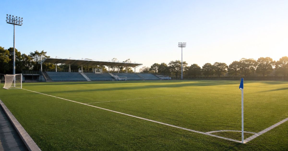 関西学生サッカーリーグの試合開始前、観客や選手が入る前の静かなサッカーグラウンドと観客席