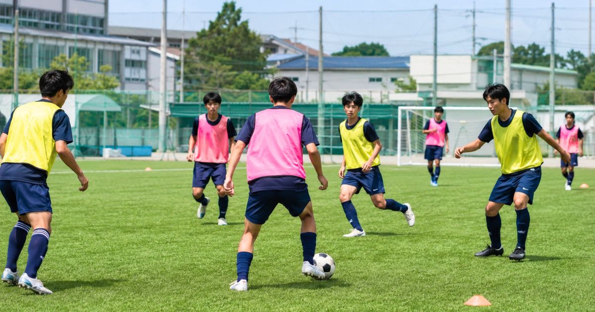 高校サッカー部の練習グラウンドで、ビブスを着用した選手たちがミニゲームに取り組む様子