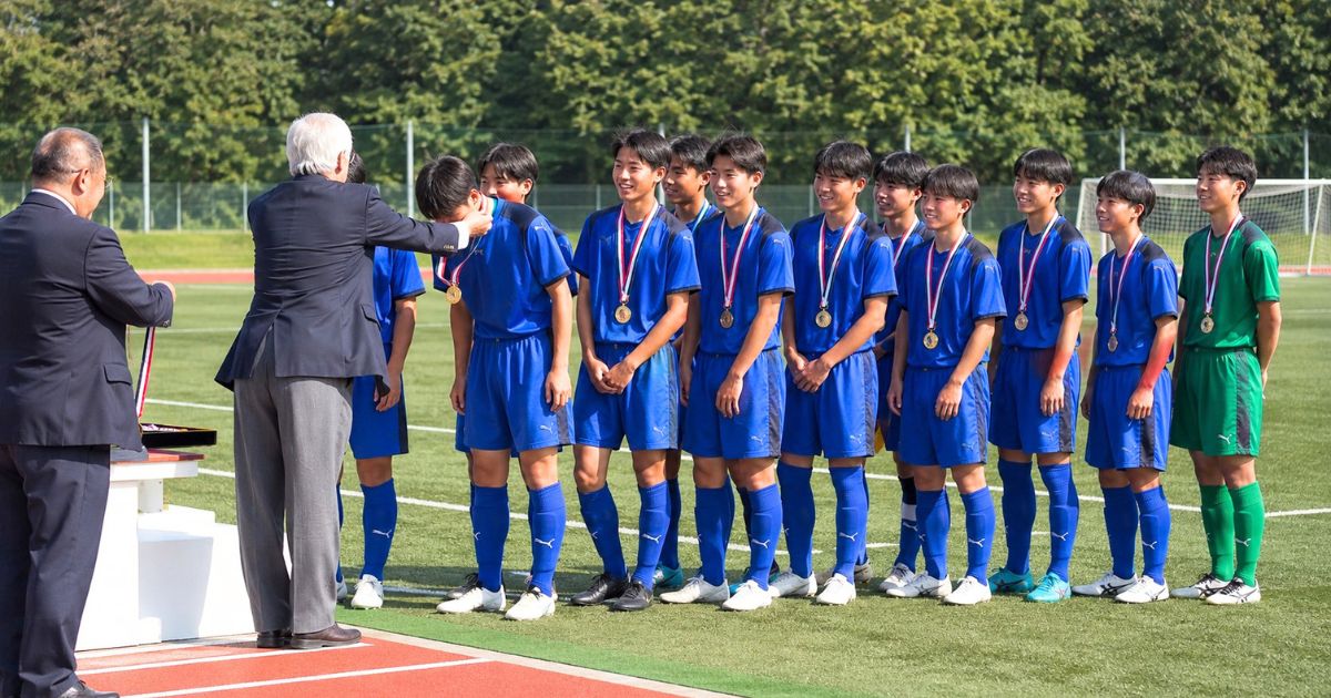 高校サッカーの都道府県大会で上位入賞しメダルを受ける選手たち
