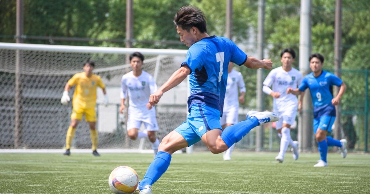関西国際大学サッカー部の選手が公式戦で強烈なシュートを放つ場面