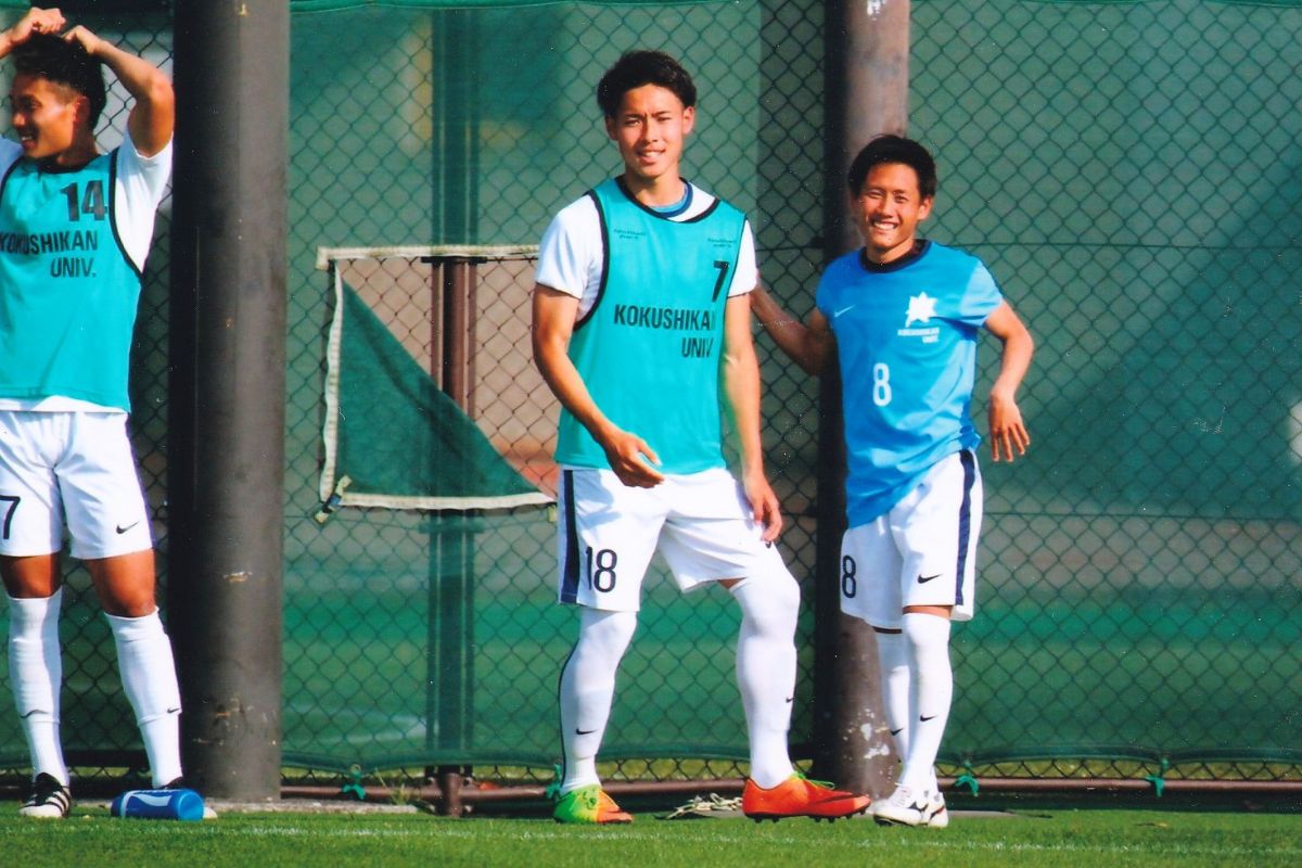 国士舘大学サッカー部時代にトレーニングウェア姿でピッチ脇に立つ選手たち