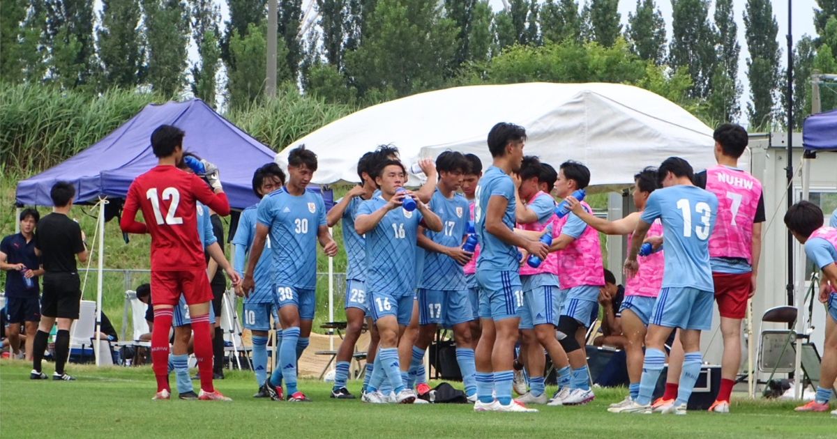 新潟医療福祉大学男子サッカー部の選手たちが公式戦のベンチ前で給水や声かけを行う様子