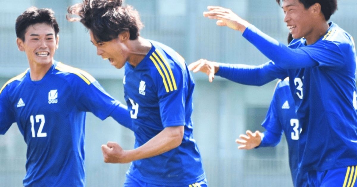 大阪学院大学サッカー部の青いユニフォーム姿の選手たちが喜ぶ試合中の様子