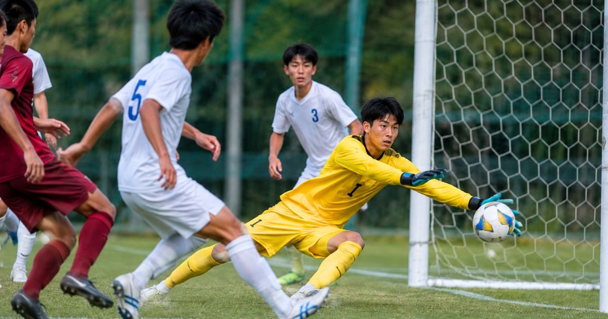 大阪大学サッカー部のポジション別競技環境をイメージした背番号1のGKが公式戦でゴールを守る場面