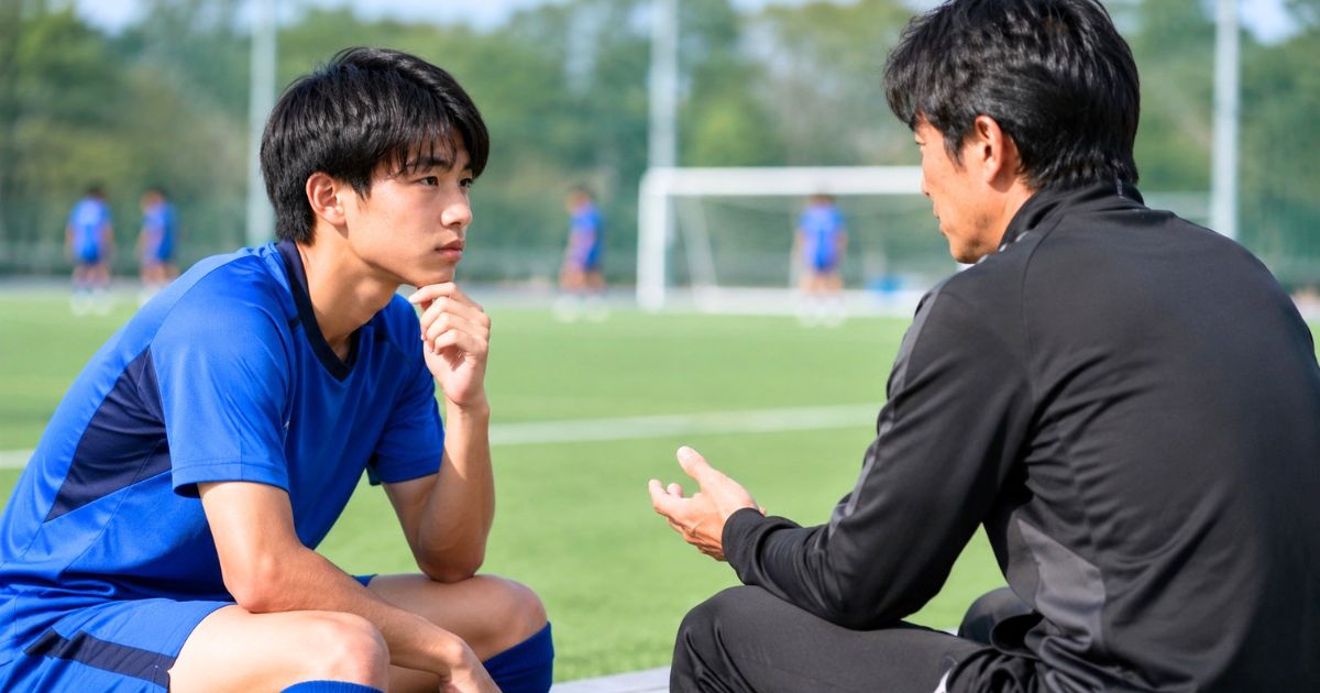 大学サッカー部のグラウンドで入部条件についてコーチに相談する高校生