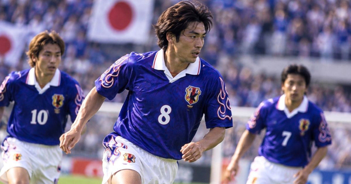 1998年モデルをイメージした青いユニフォームでプレーするサッカー日本代表選手