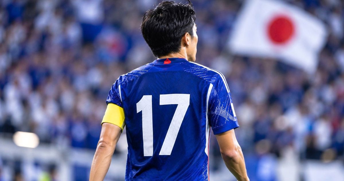 日本代表をイメージした青い17番ユニフォームを着用し、キャプテンマークを巻いてピッチに立つ選手の後ろ姿