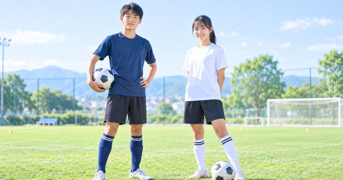サッカーグラウンドで練習着姿の男子ユース選手と女子ユース選手が並んで立つ様子
