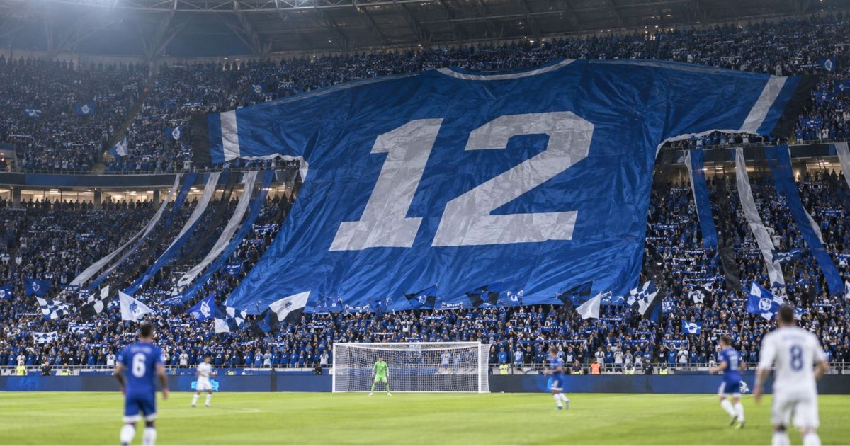 スタンドの観客席に背番号12の巨大ユニフォームが広げられたサッカー stadium の応援風景