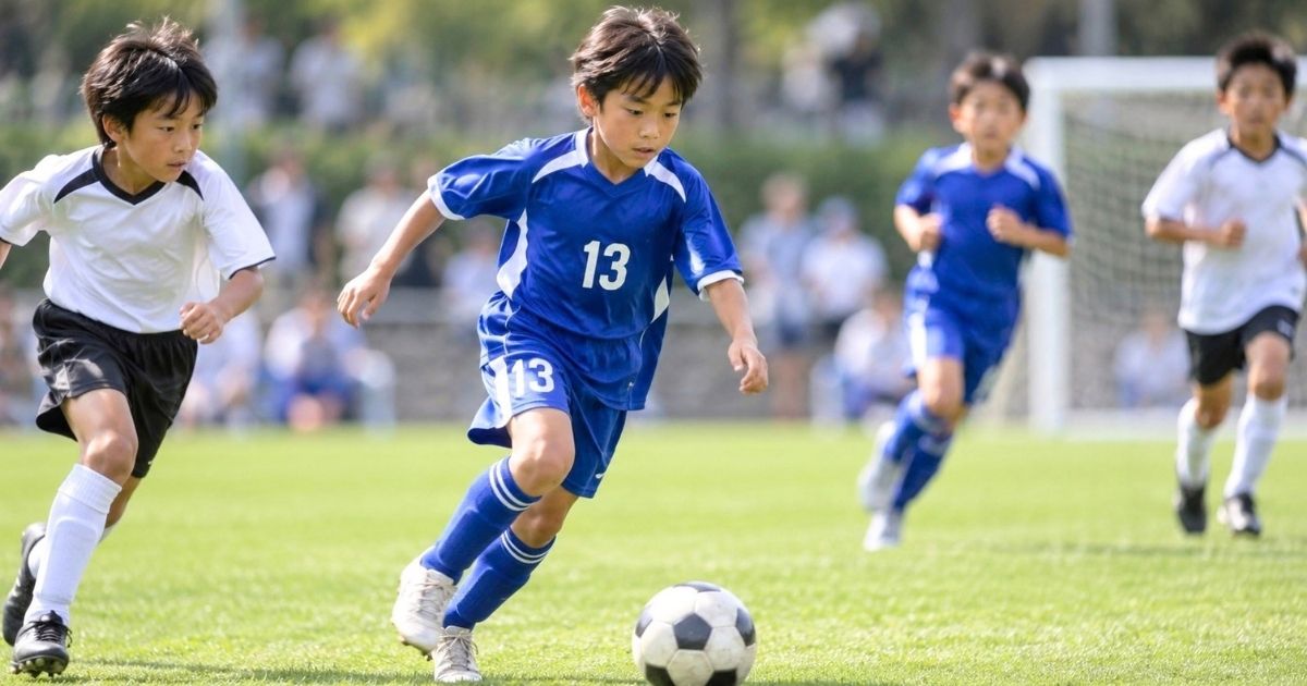 少年サッカーの試合で背番号13の選手がボールをドリブルするプレーシーン
